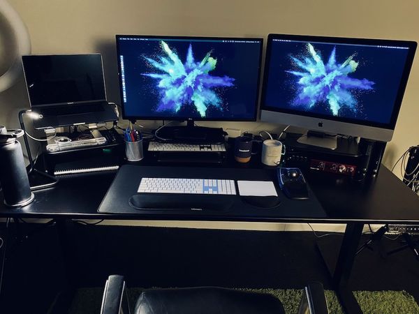 Picture of two computers on a standing desk from the front