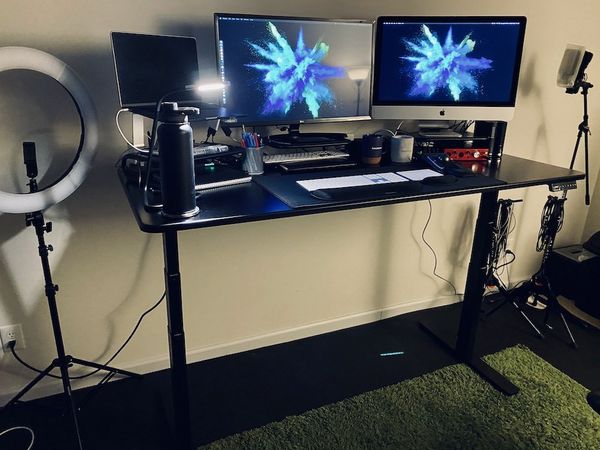 Picture of two computers on a standing desk with the desk raised